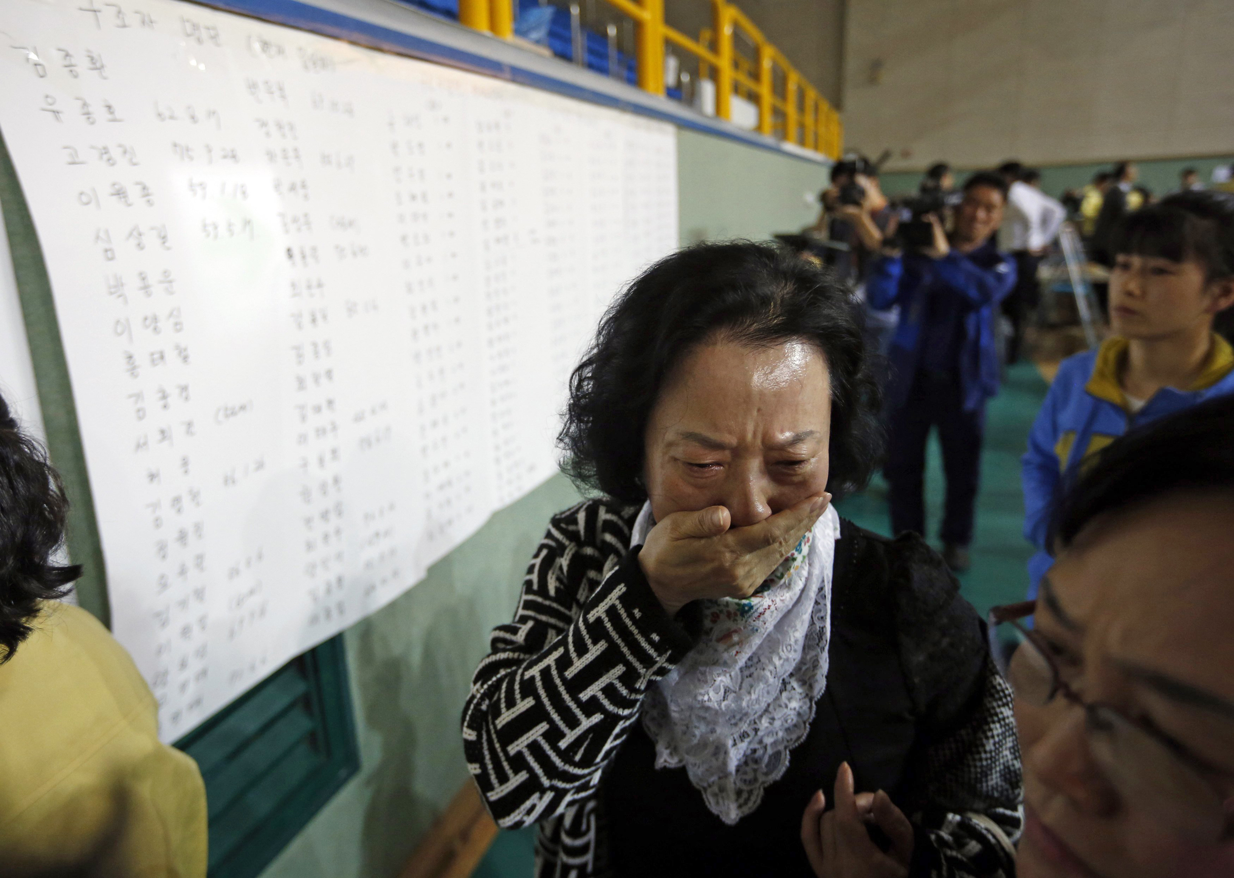 Image: The mother of a passenger who was on a sinking ferry reacts after finding her son's name in the survivors list in Jindo