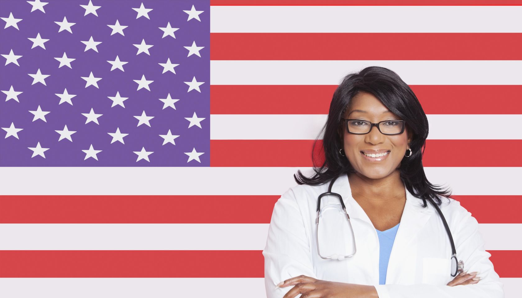 Portrait of confident mixed race female surgeon over American flag
