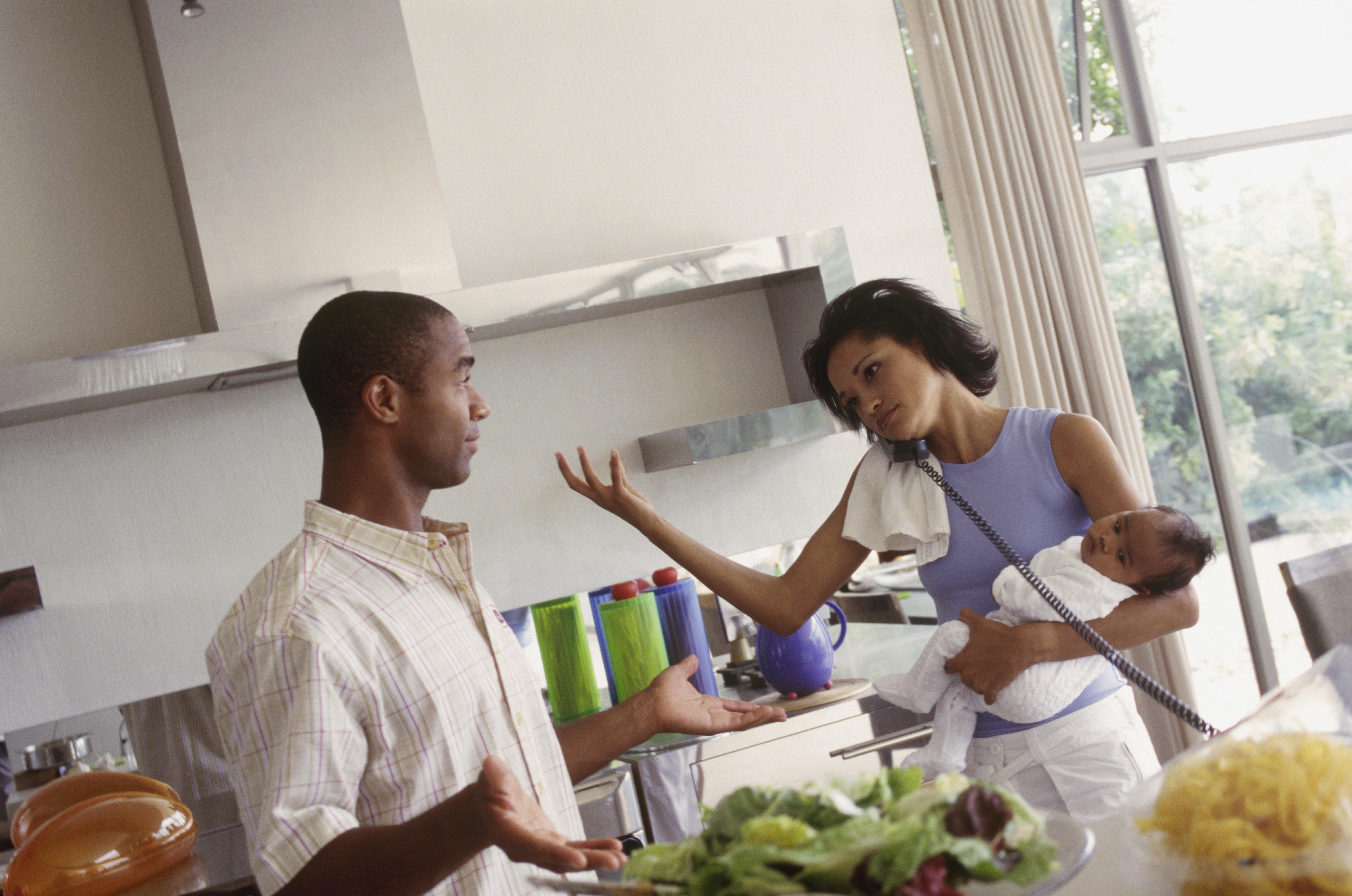 Couple in the kitchen together, busy mom on telephone