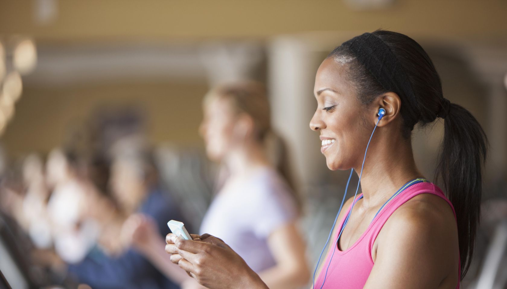 African American woman using cell phone in gym