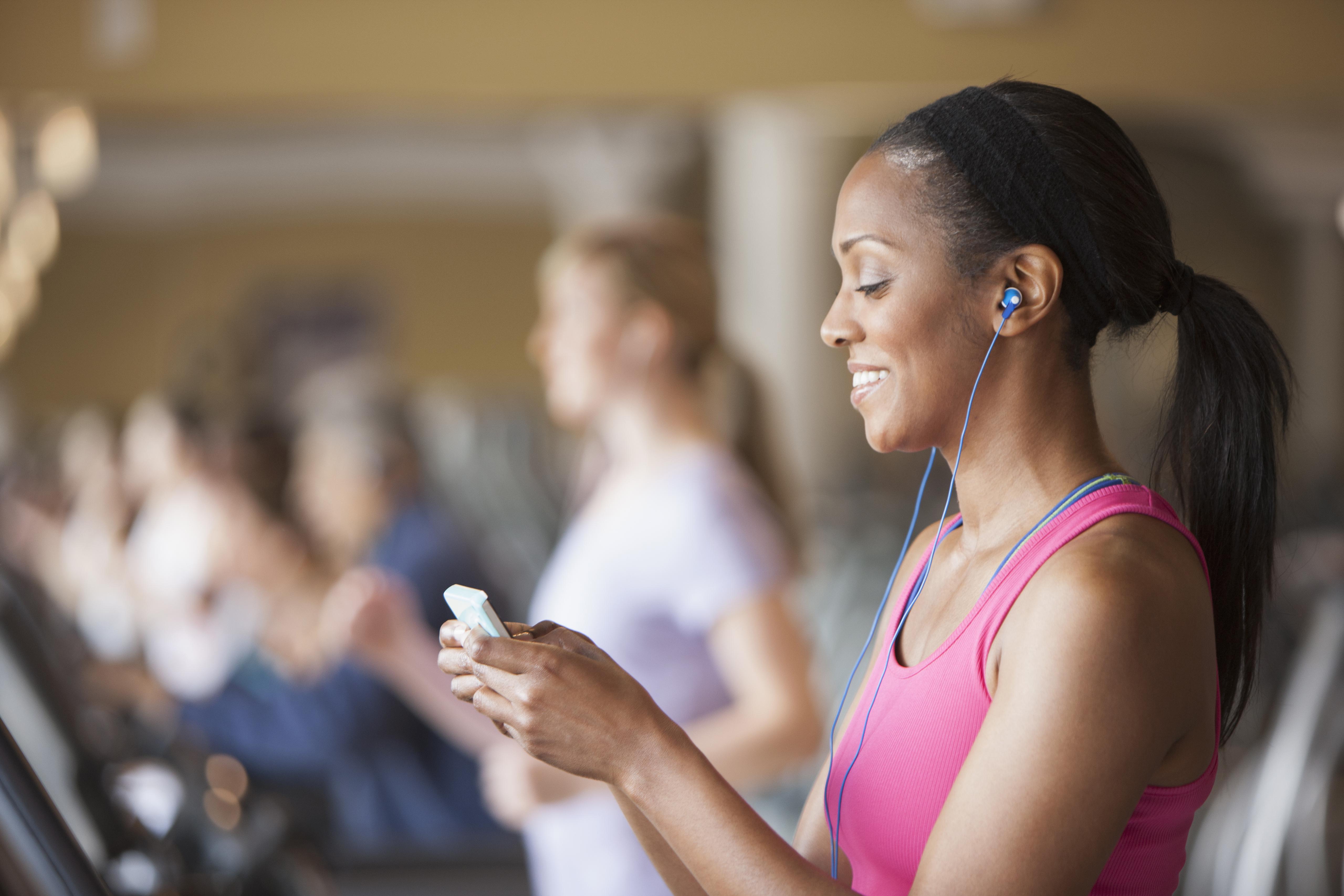 African American woman using cell phone in gym