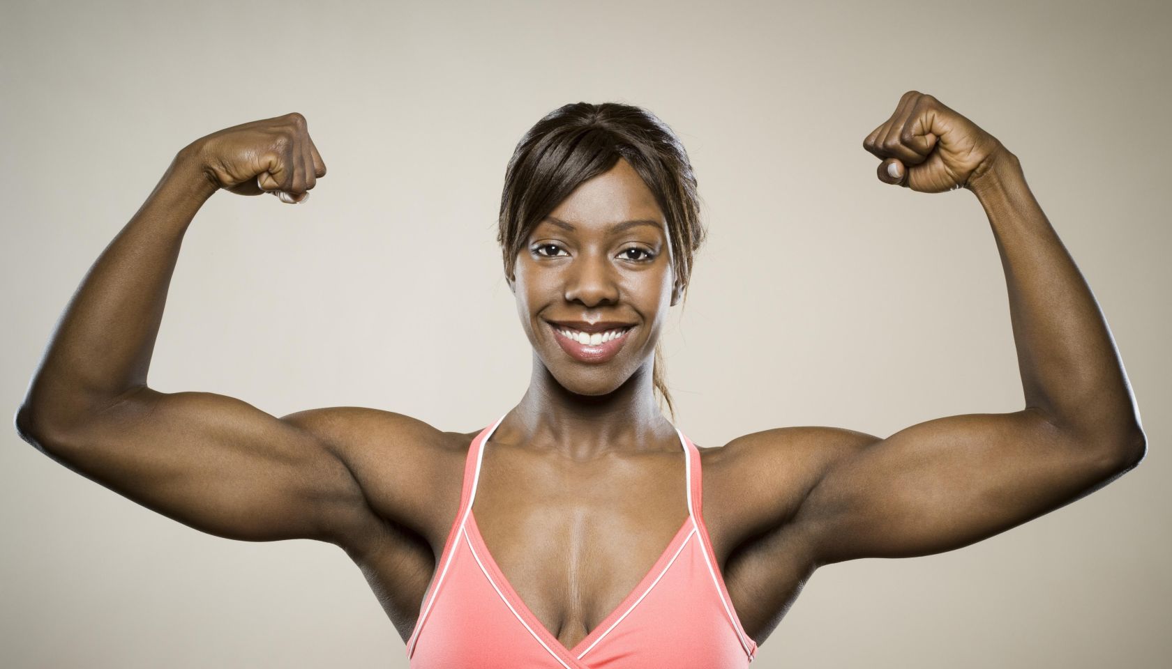 Portrait of a young woman flexing her muscles