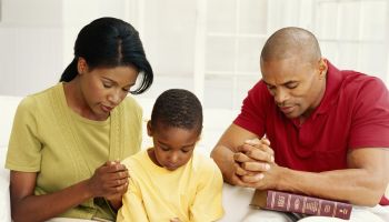 Parents with son (6-9) praying
