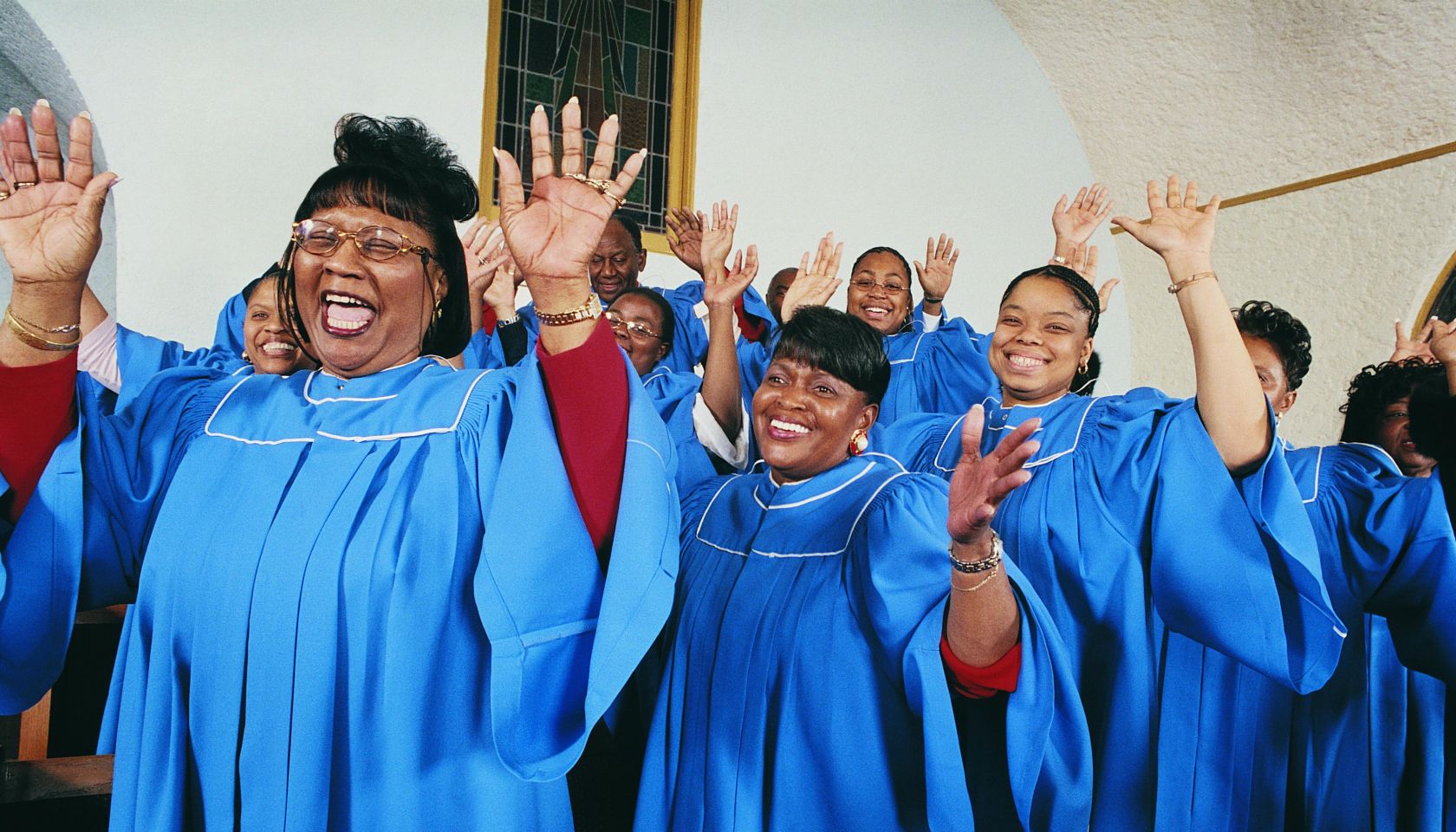 Twelve Gospel Singers With Raised Hands Singing in a Church Service