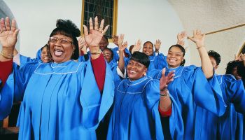 Twelve Gospel Singers With Raised Hands Singing in a Church Service