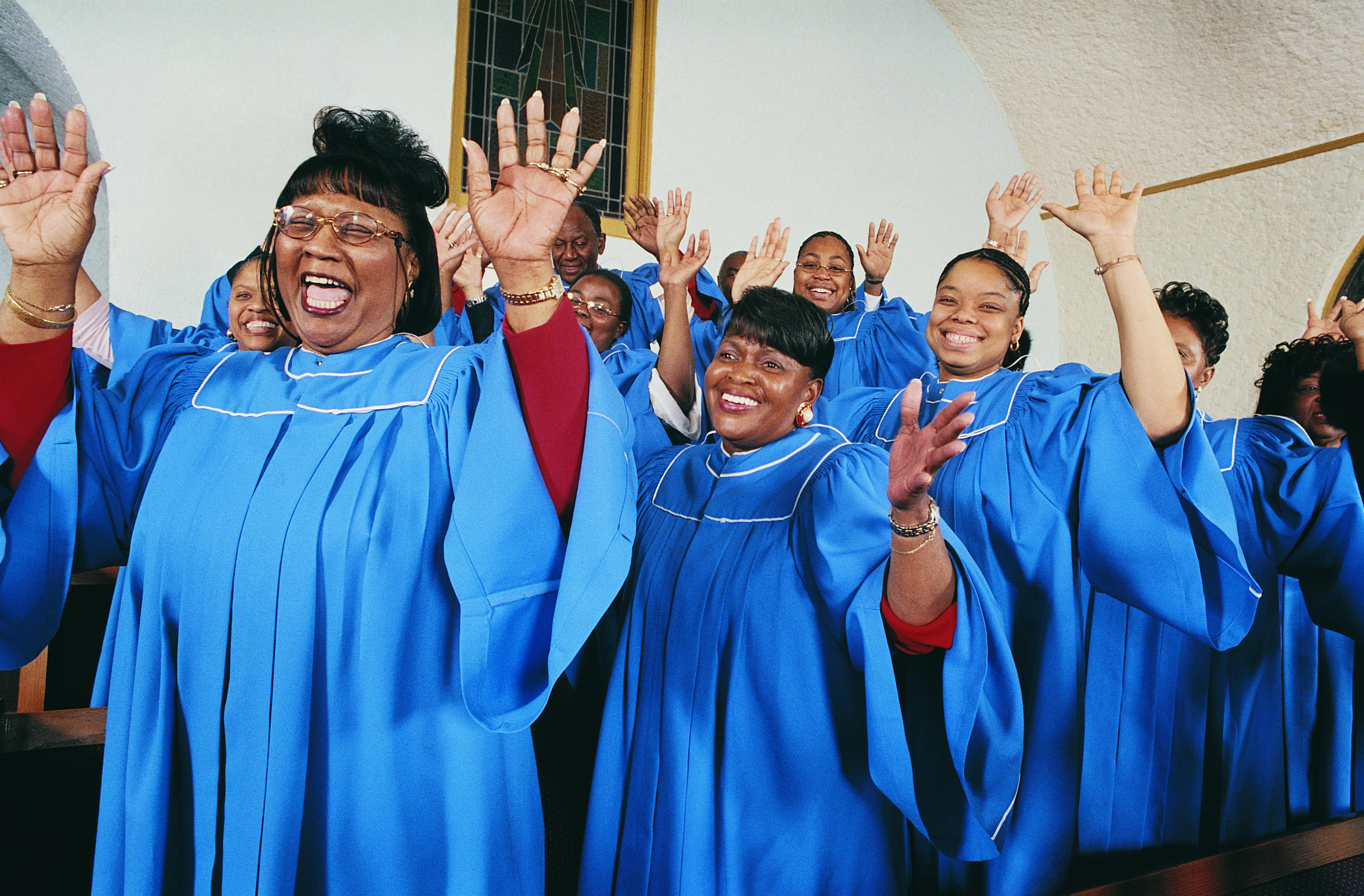 Twelve Gospel Singers With Raised Hands Singing in a Church Service