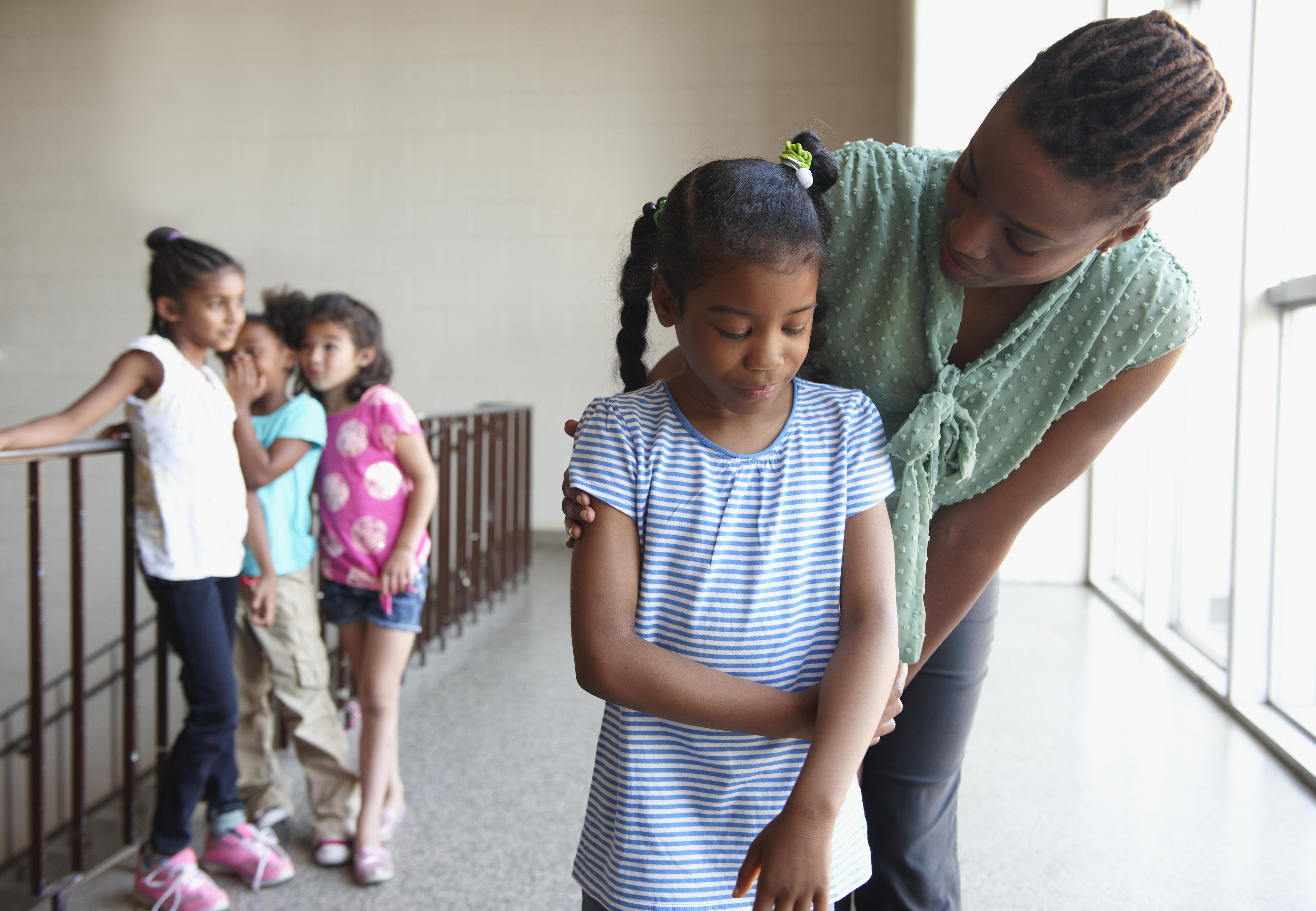 Teacher talking to bullied young girl