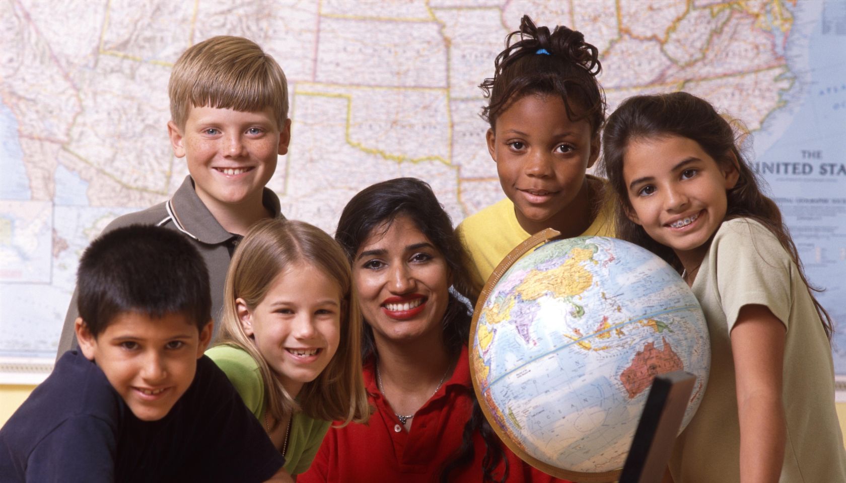 Teacher and students with world globe and laptop
