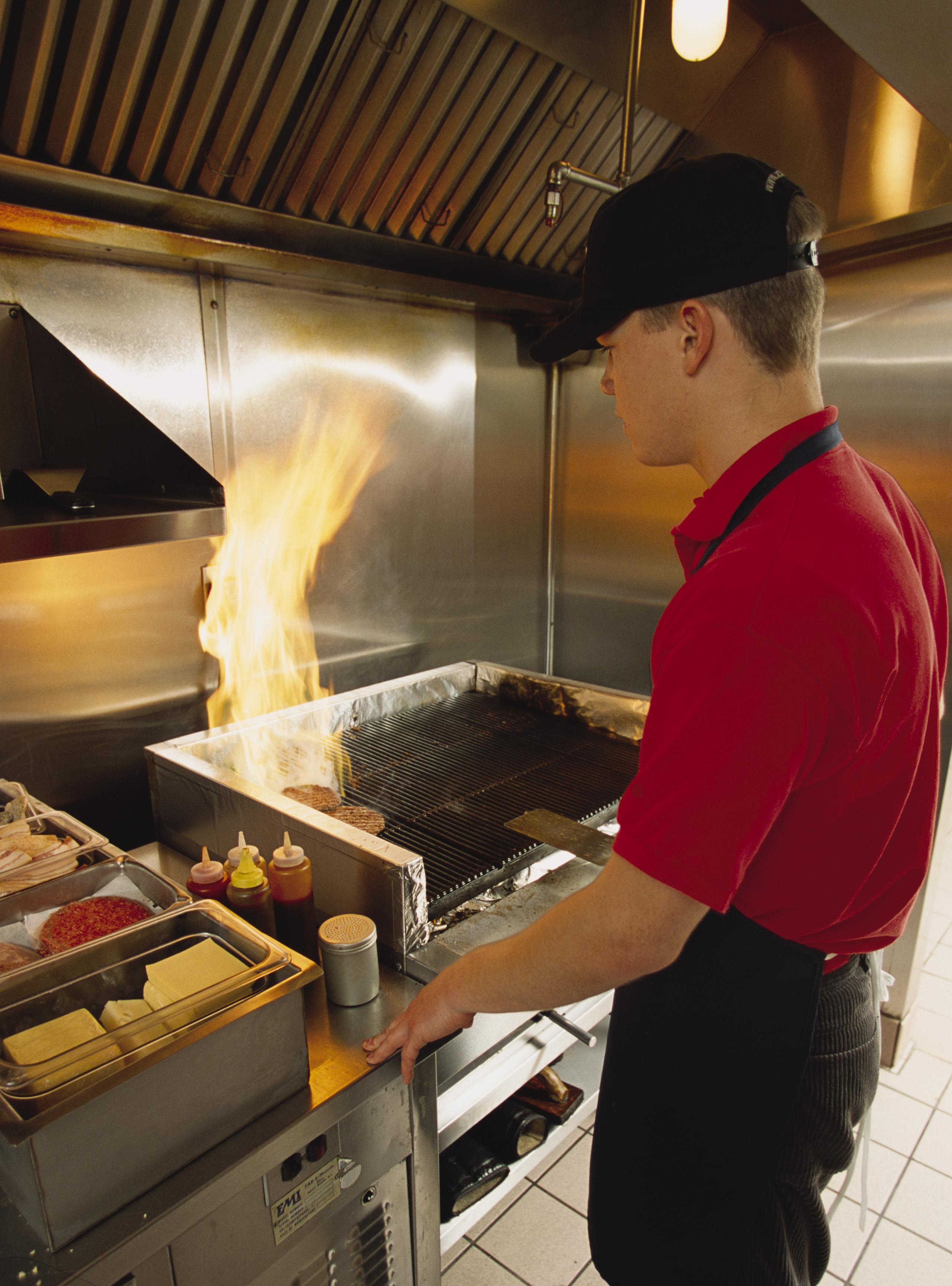 Fast food worker flips hamburgers