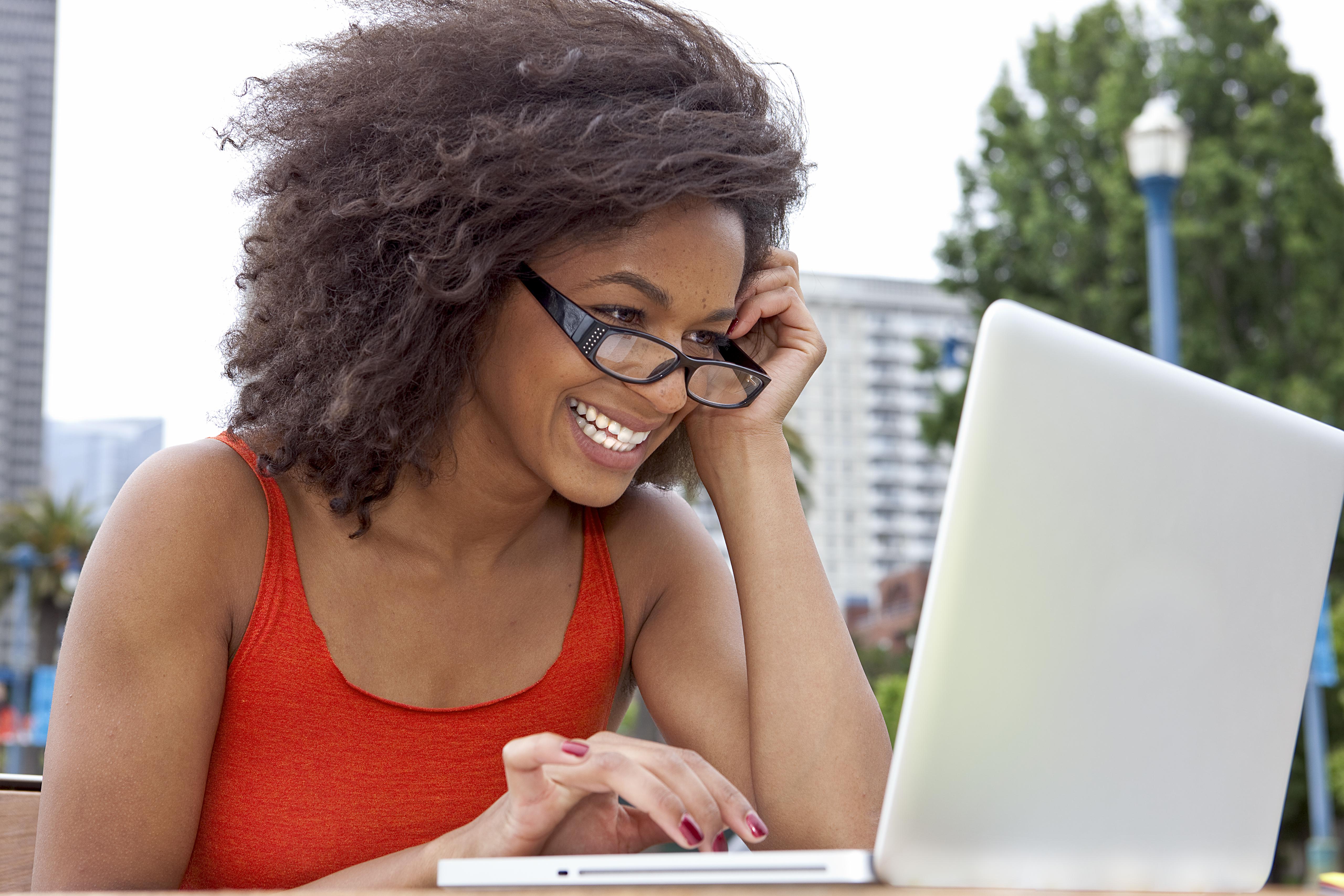 Young woman smiling working on a laptop computer