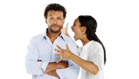 Portrait of young woman shouting at her boyfriend against white background