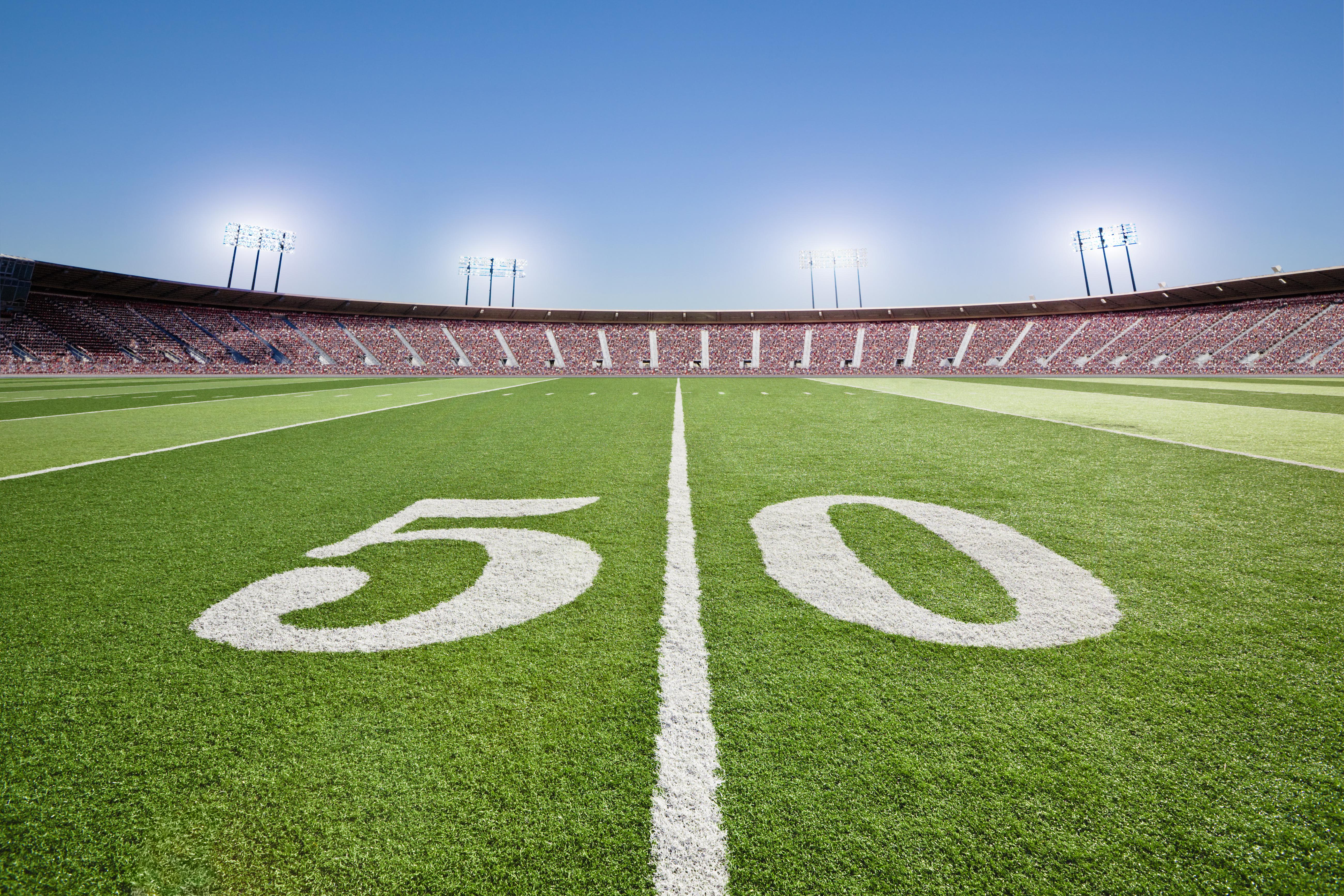 50 yard line on football field in stadium.