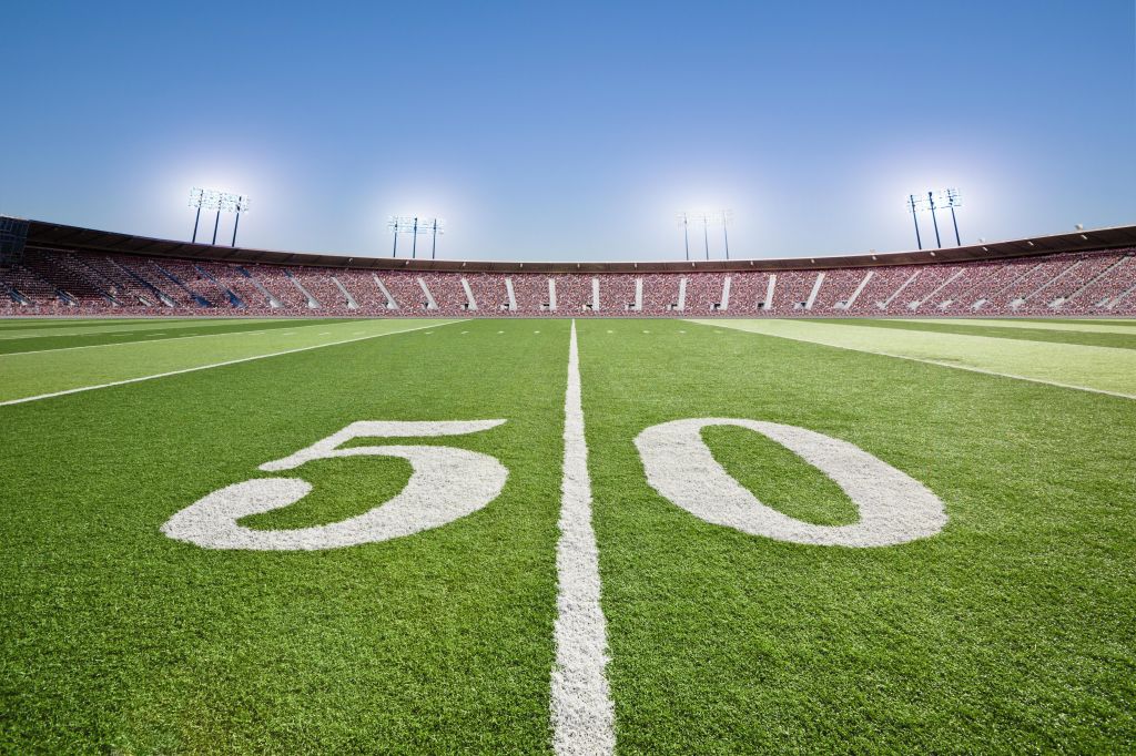 50 yard line on football field in stadium.