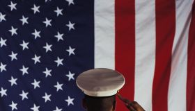 Man in U.S. Marine Corps uniform saluting American flag