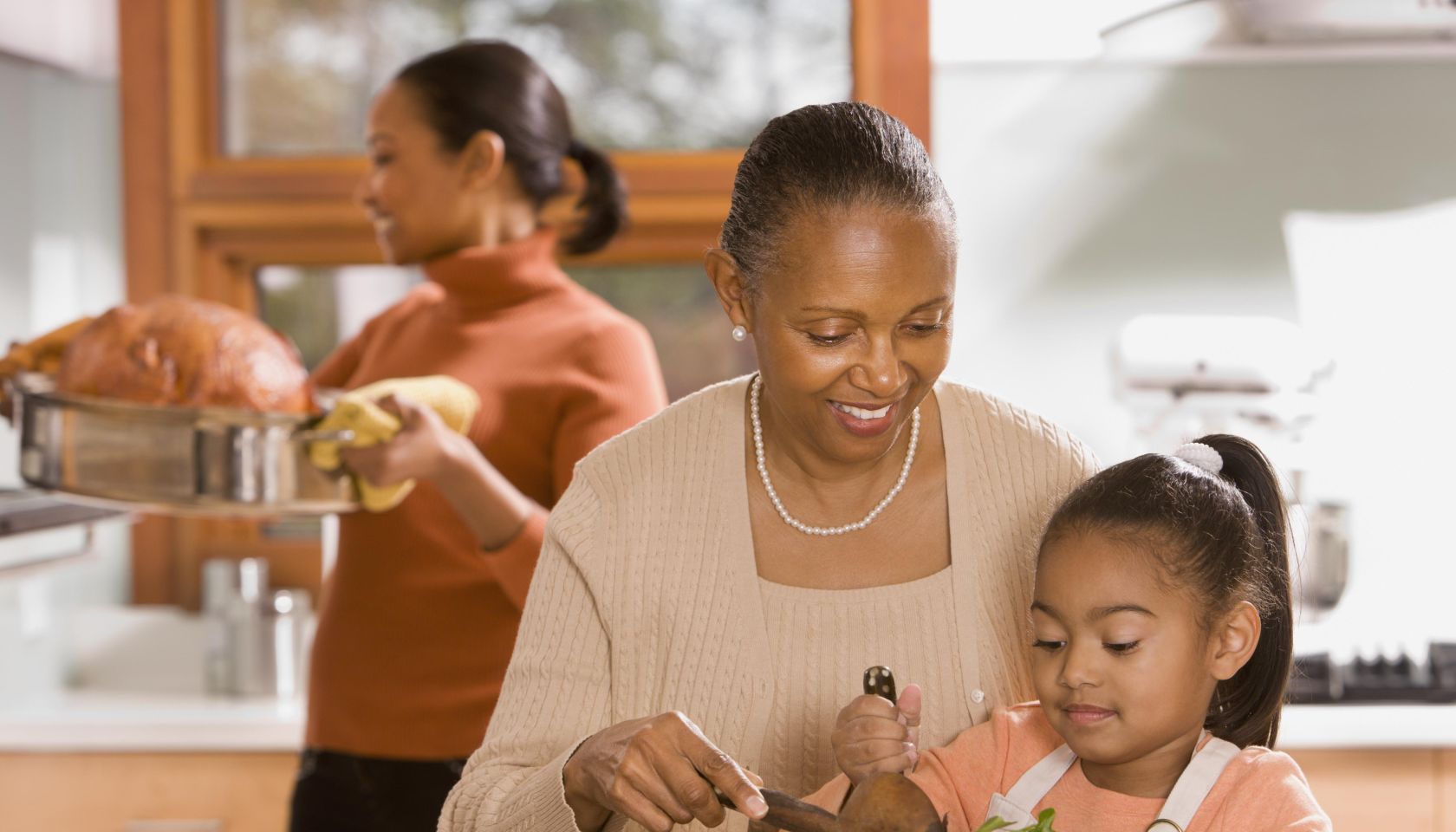 African grandmother, mother and daughter preparing food