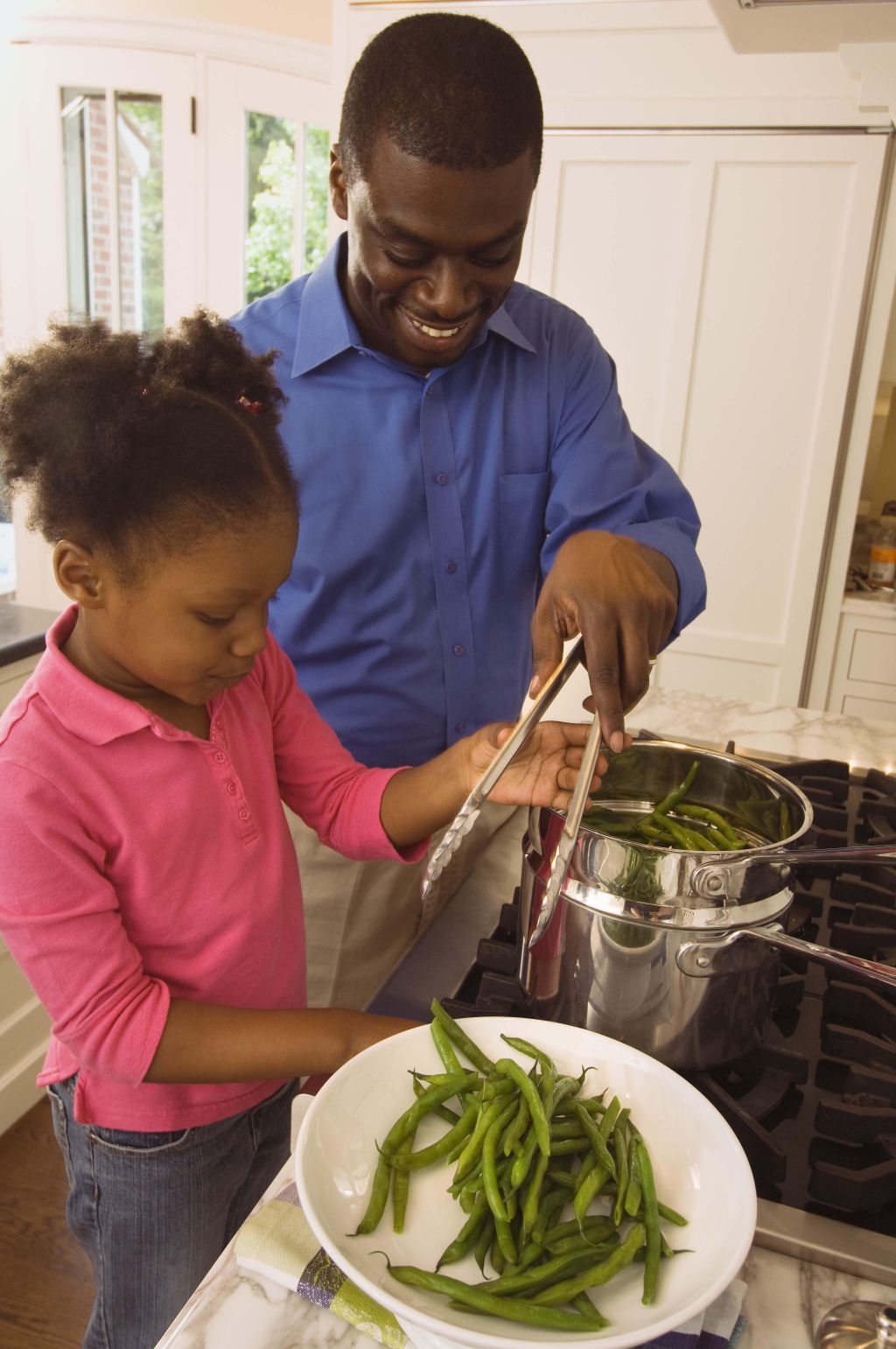 Father and daughter cooking greens