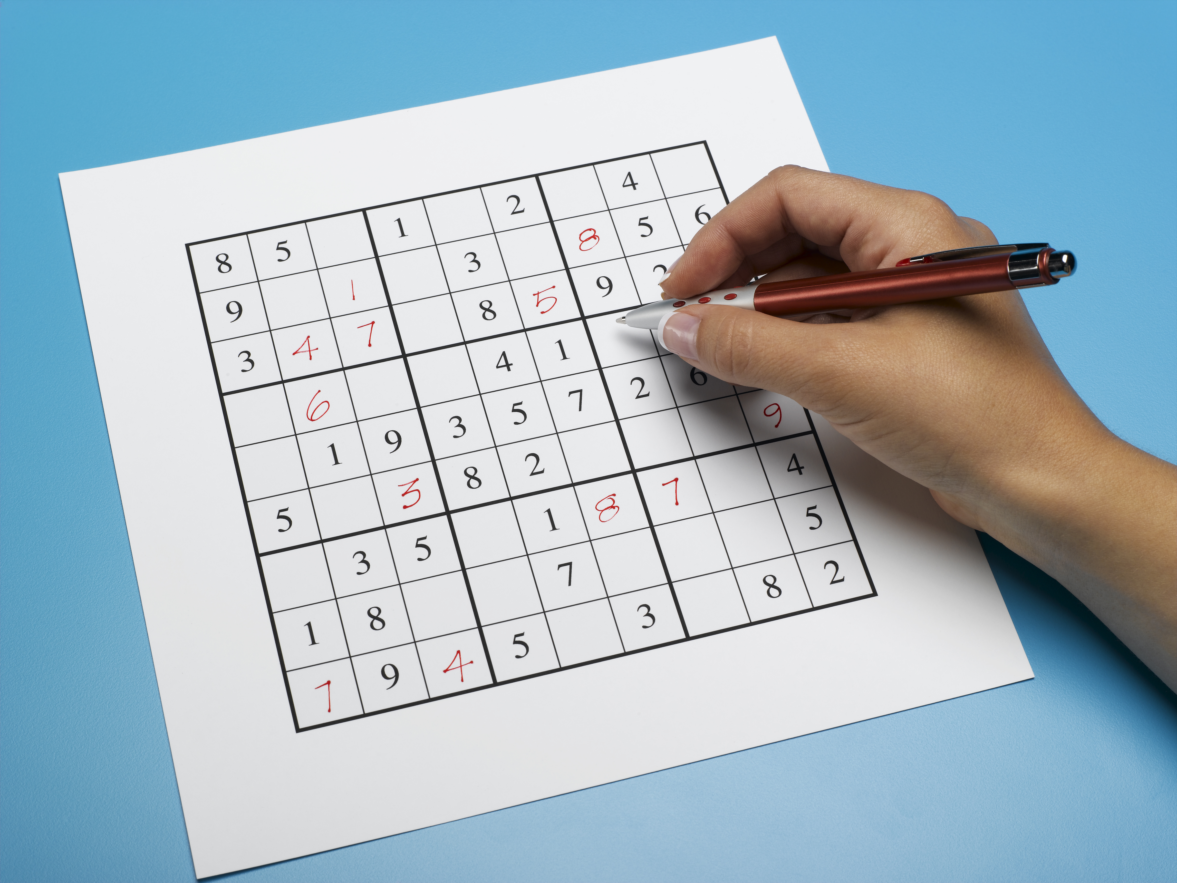 Woman doing sudoku puzzle, close-up
