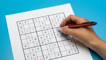 Woman doing sudoku puzzle, close-up