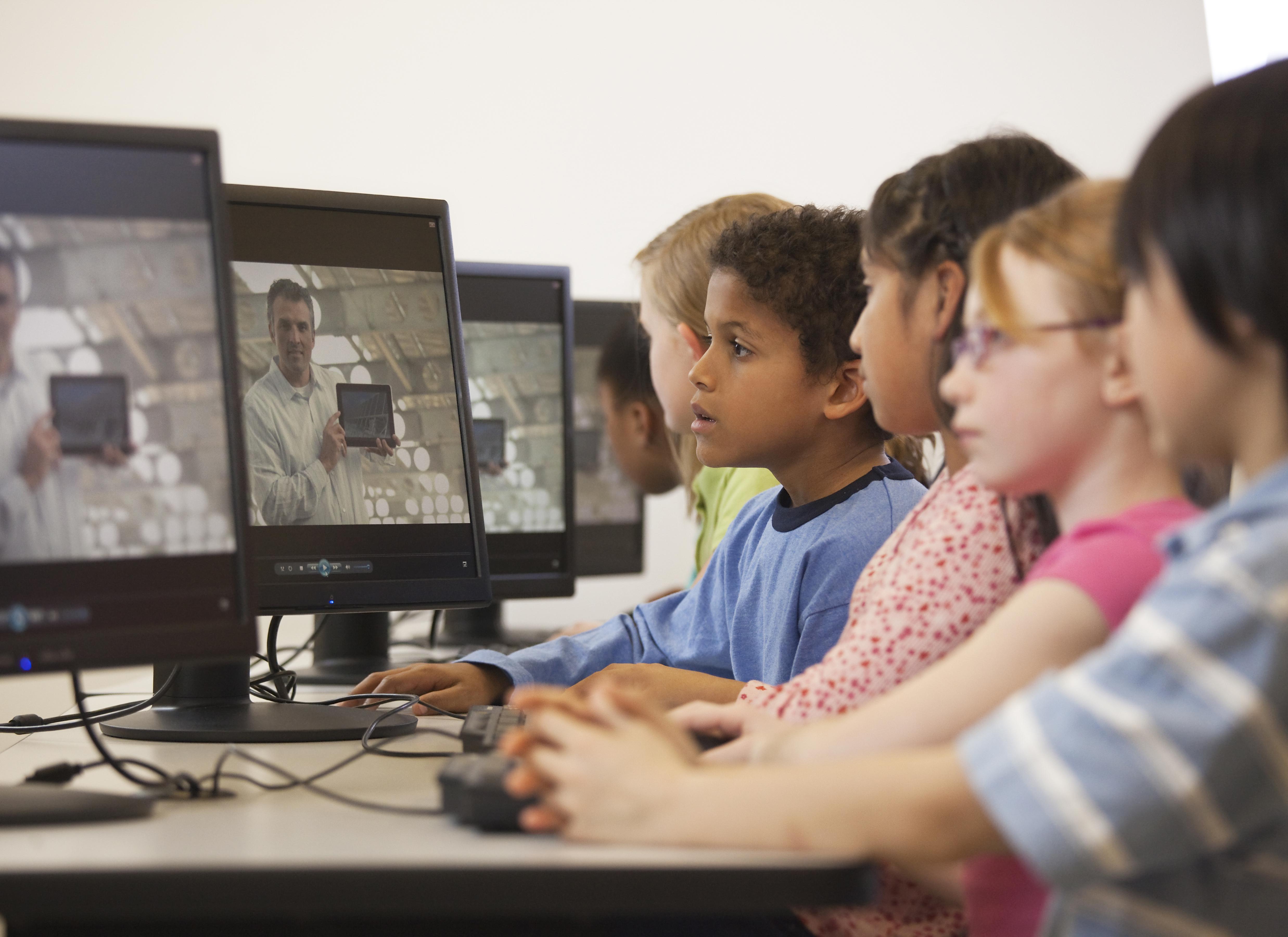 Children watching online instruction in computer lab