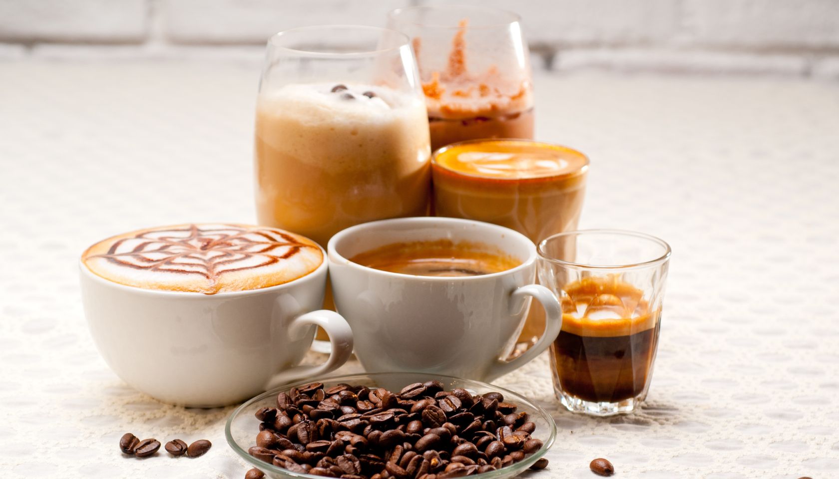 Close-Up Of Coffees With Roasted Coffee Beans Served On Table
