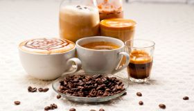 Close-Up Of Coffees With Roasted Coffee Beans Served On Table