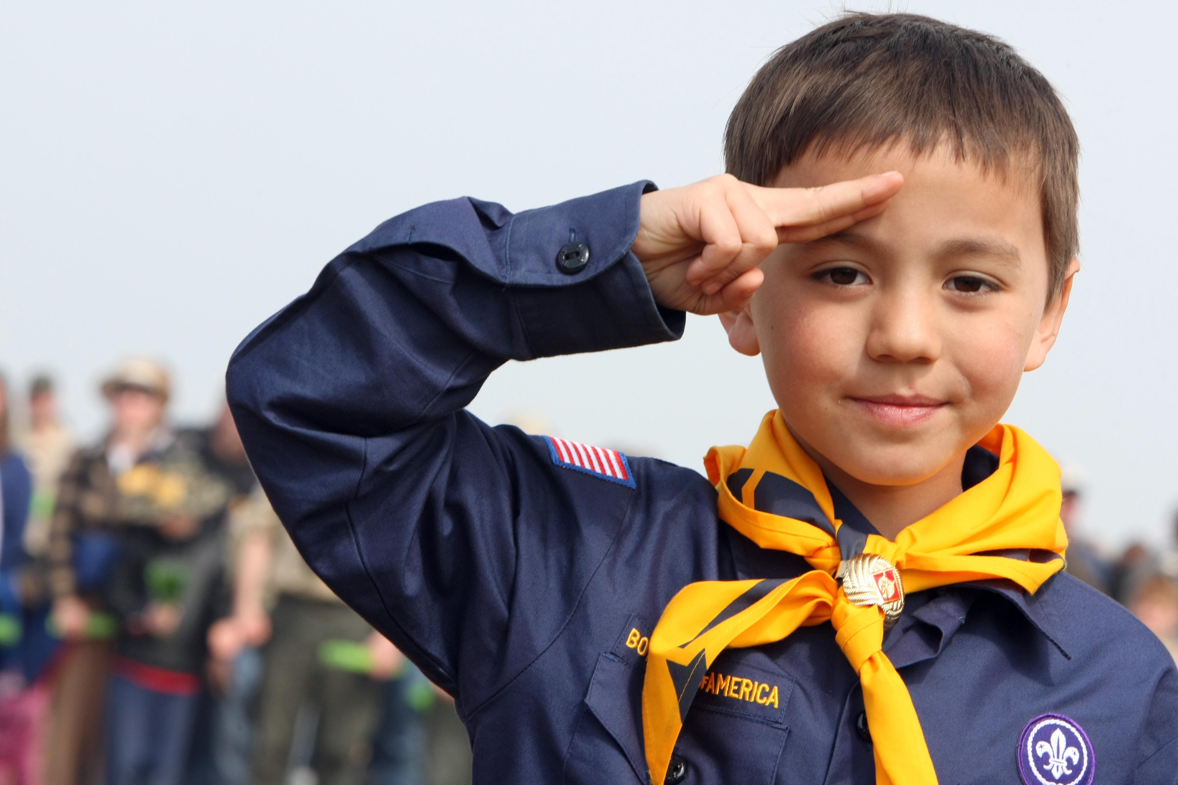 A US boy scout salutes while listening t