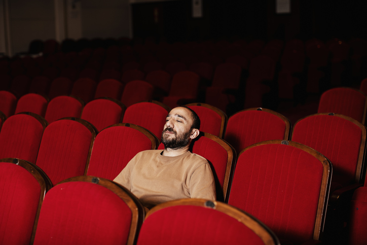 Man Looking Away While Sitting On Chair In Theater
