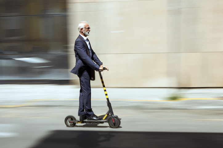 Businessman riding a electric scooter in the city