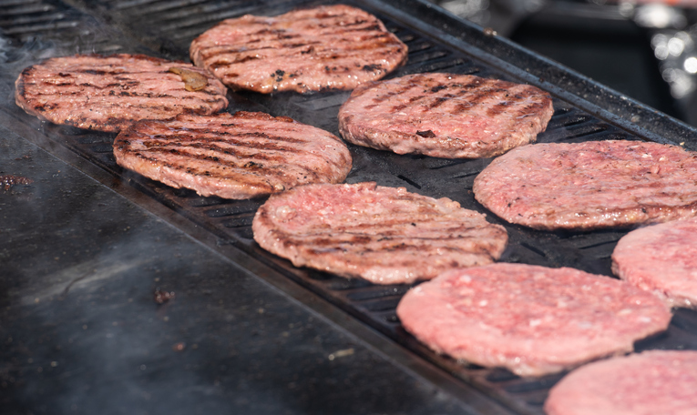 Hamburgers cooking on a griddle