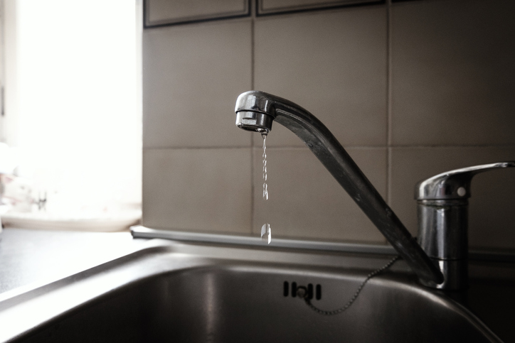 Close-Up Of Water Dripping From Faucet In Domestic Kitchen