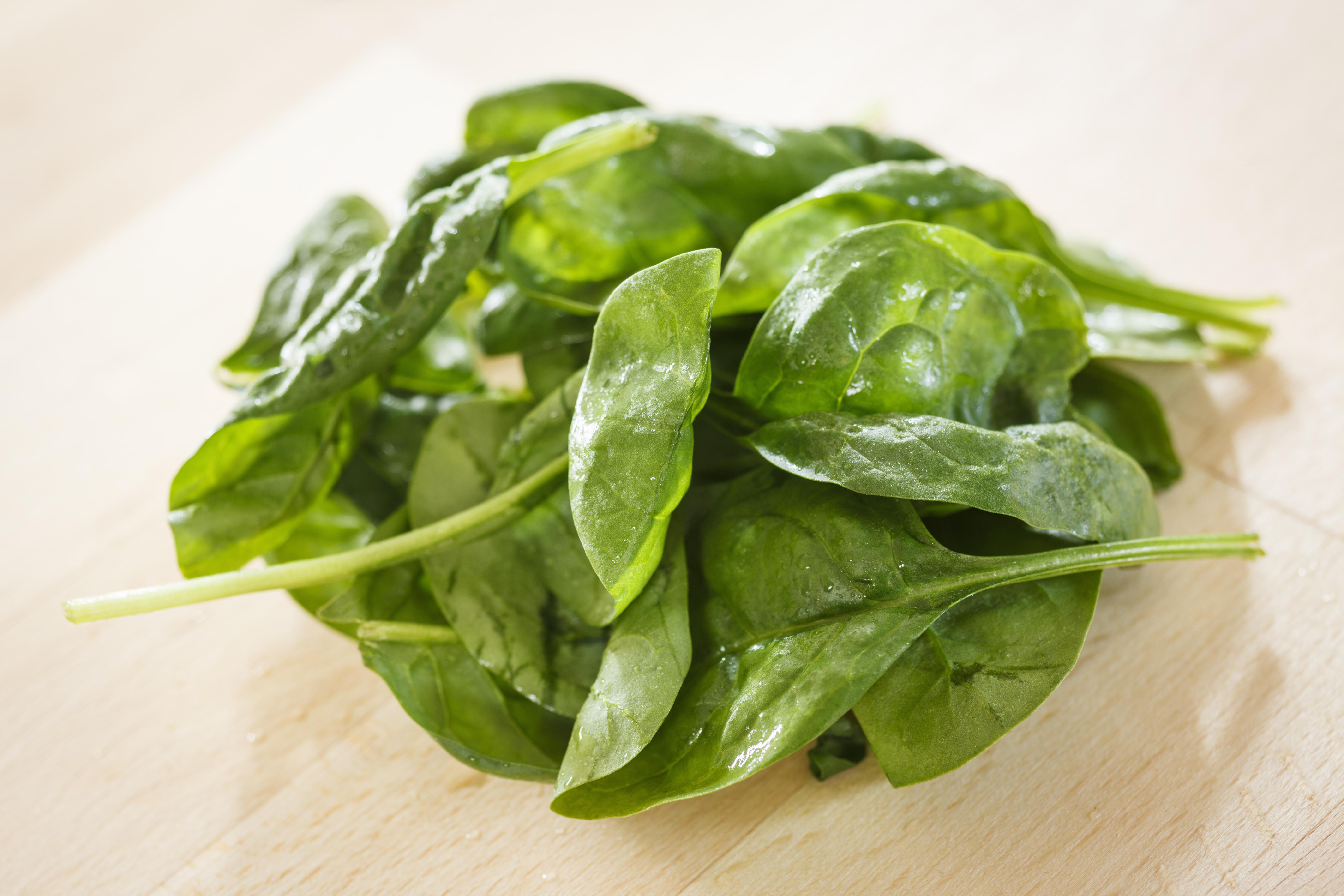 Bunch of fresh spinach on a wooden table