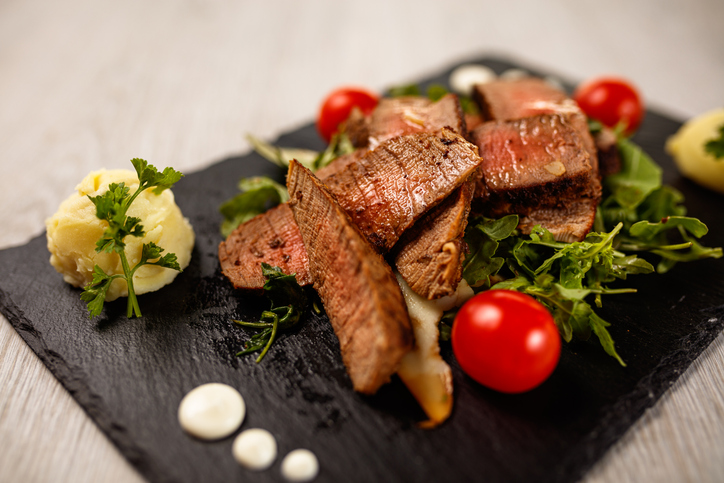 Delicious Tagliata Steak on black stone plate