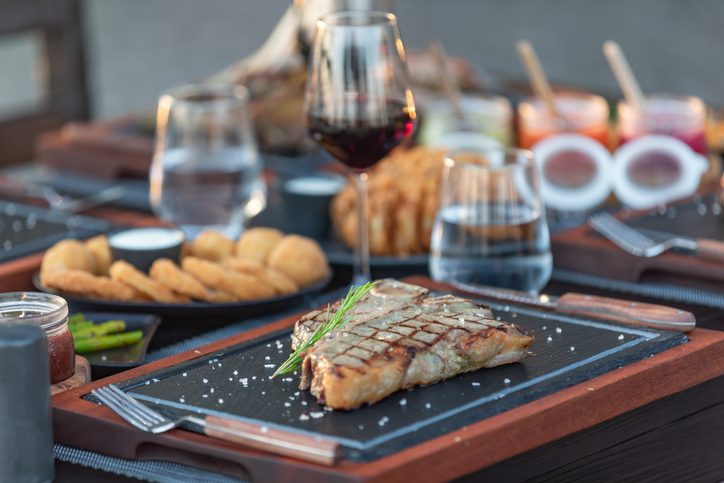 Steak House outdoor table with variety meat dishes - Hotel Luxury Restaurant