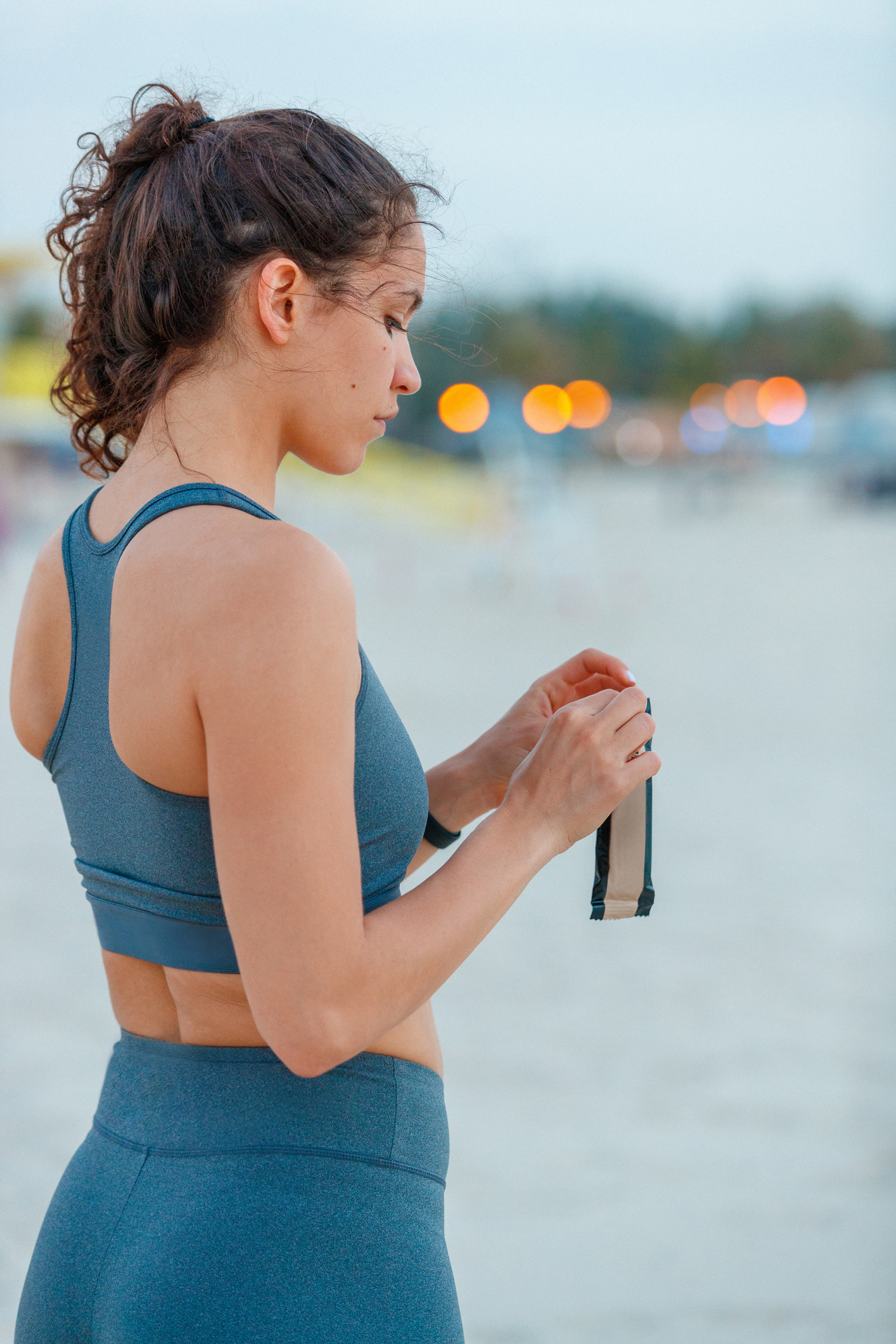 Female jogger opening a protein bar