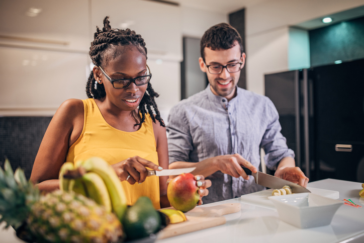 Couple making fruit salad in the kitchen