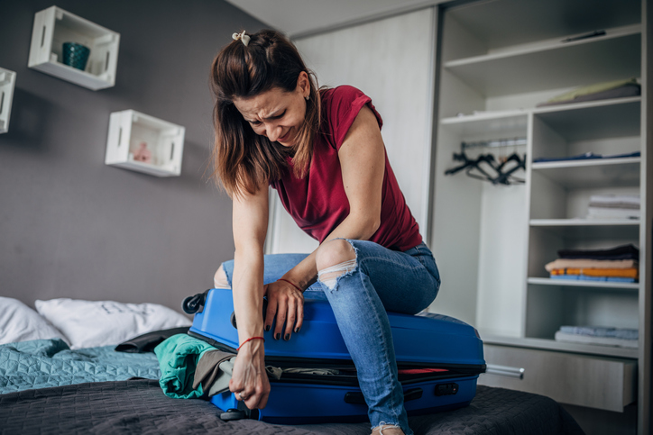 Woman is struggling to suitcase