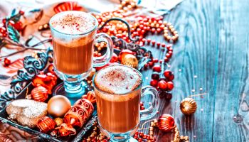 Two Cups of Hot Coffee or a Cappuccino on Tray with Christmas Decorations on Wooden Background