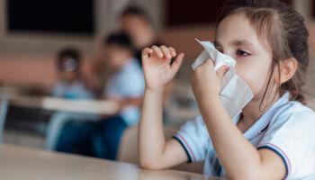 Preschooler wiping nose with tissue