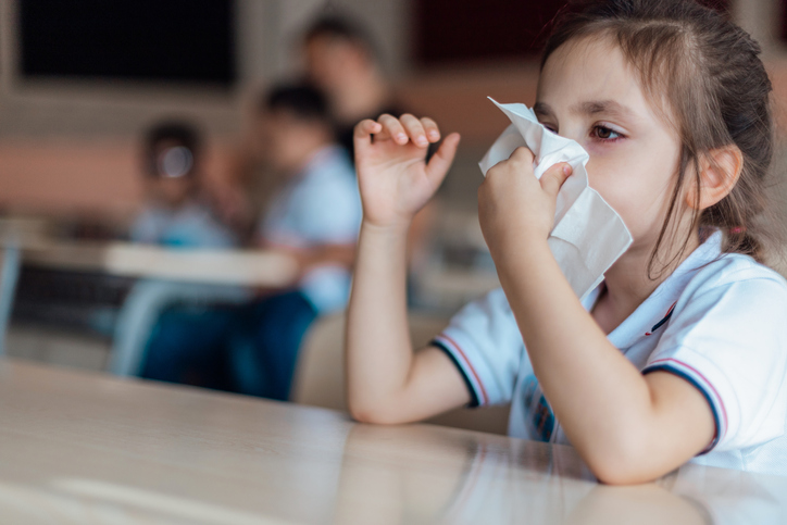 Preschooler wiping nose with tissue
