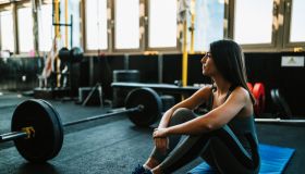Woman resting after lifting weights in the gym
