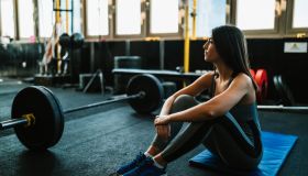 Woman resting after lifting weights in the gym