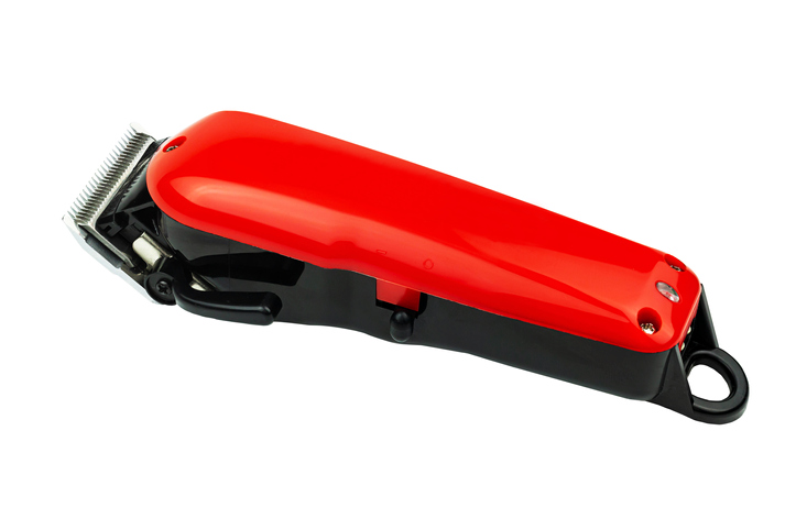 Close-Up Of Red Hair Clipper Over White Background