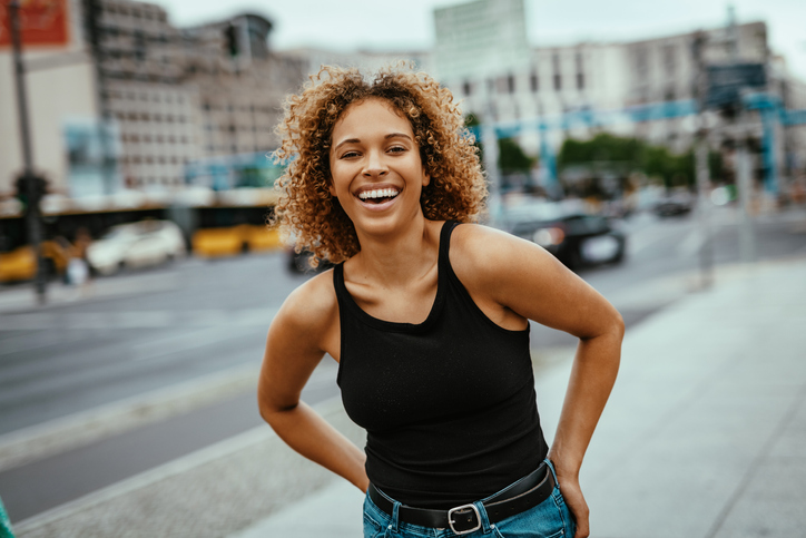 Portrait of mixed race curly woman in city