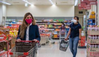 Shoppers seen wearing protective face masks as they shop in...