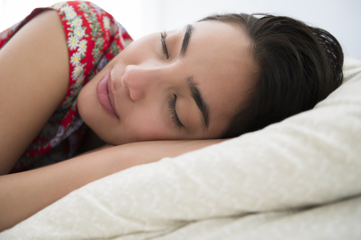 Sleeping woman lying down on bed