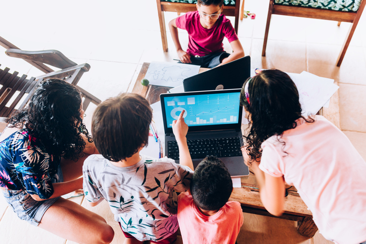 Group of children analyzing sales graph on laptop