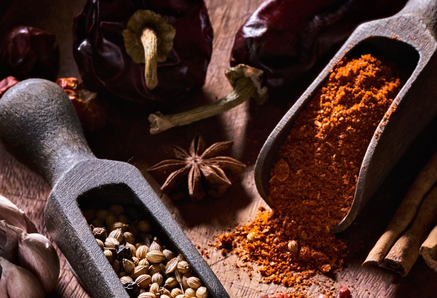 Variety of allspice and herbs on rustic wood table