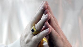 DENVER, CO-- A clergy member clasps his hands together on the Pulpit during Communion for "The Holy Sacrifice of the Mass," opening the 129th Supreme Convention for the Knights of Columbus international convention at the Sheridan Hotel in downtown Denver