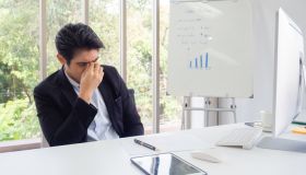 Young Depressed Businessman Sitting At Office