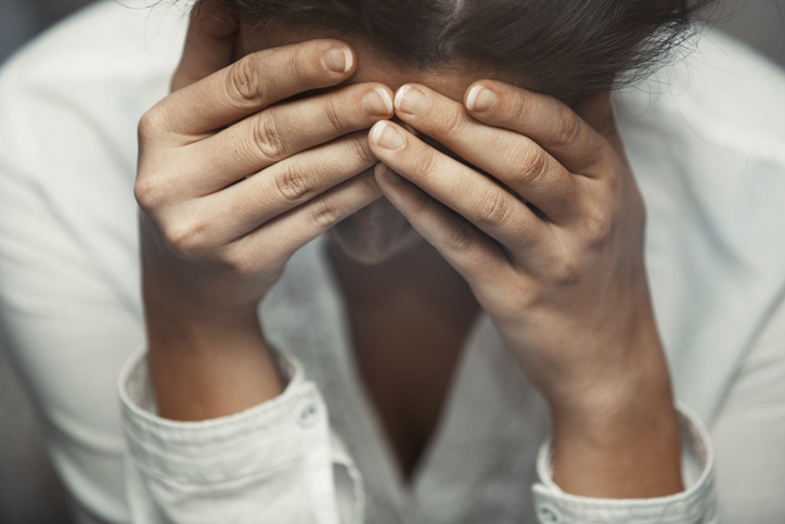 Woman in distress covering her face with hands